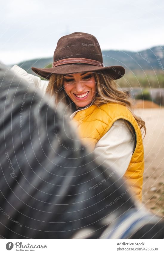 Joyful stylish young woman embracing horse in pasture cuddle owner love friend animal countryside smile happy equestrian together pet female blond style trendy