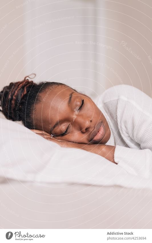 Young black woman sleeping on comfy bed at home eyes closed relax lying bedroom pillow asleep morning calm cozy female young african american ethnic human face