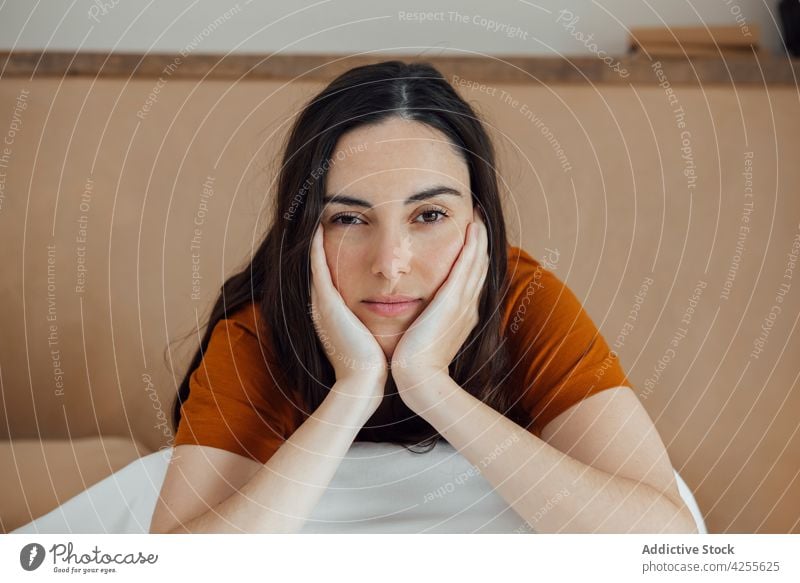 Dreamy woman sitting on comfortable bed in morning dreamy lean on hand bedroom content positive peaceful serene lifestyle attractive brunette tender thoughtful