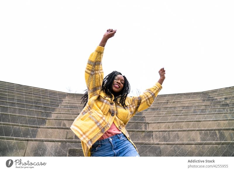 Excited black woman having fun in park enjoy happy excited posture carefree satisfied delight expressive female cheerful millennial afro pleasant hand raised