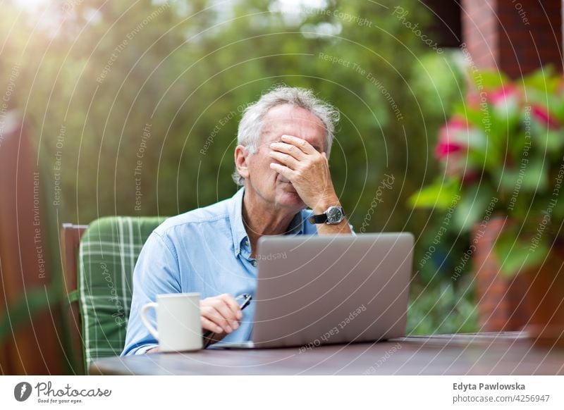 Senior man looking stressed while working on laptop computer technology internet using notebook senior old men male home house people lifestyle enjoying at home