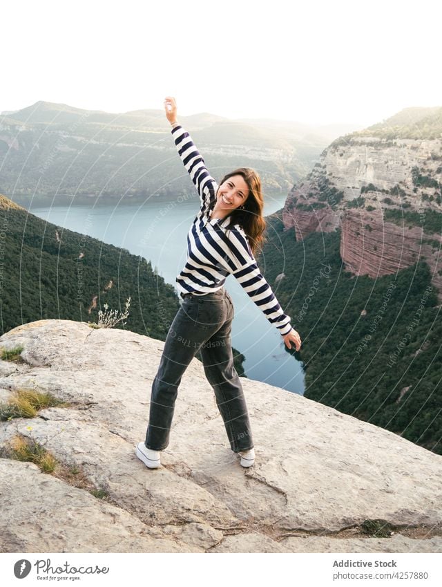 Content young Hispanic woman standing on rocky mountain in canyon hike cliff traveler nature happy journey explore trip river holiday female ethnic hispanic