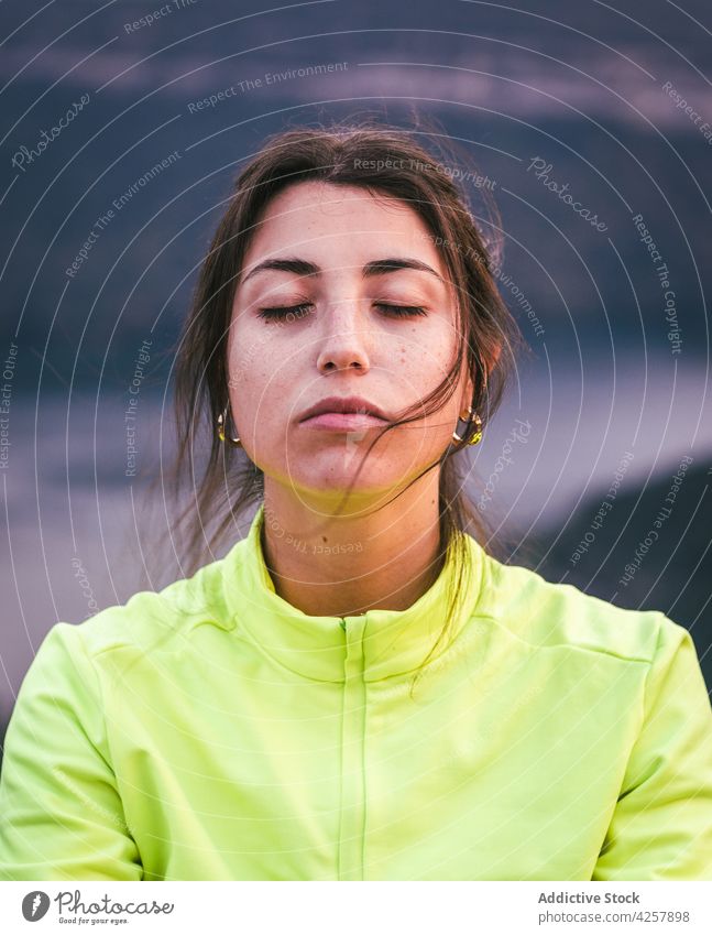 Young Hispanic lady meditating in Lotus pose on cliff edge in rocky canyon woman lotus pose padmasana meditate eyes closed yoga mindfulness nature harmony calm