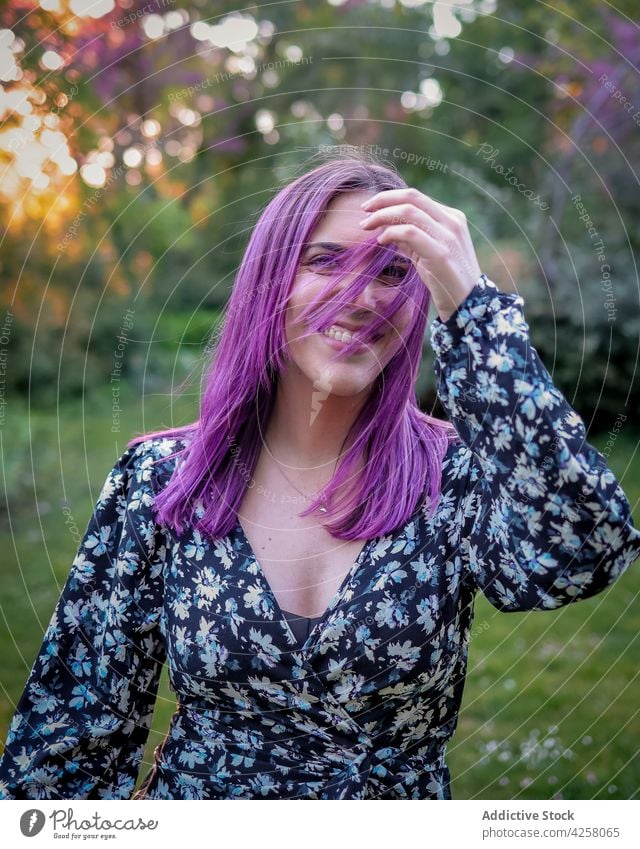 Cheerful woman standing in garden tree scent blossom bloom fragrant aroma spring flower young nature park tender flora pink delicate gentle branch dyed hair