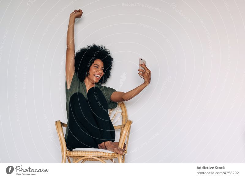 Positive black woman taking selfie near green potted plants positive smile happy smartphone take photo cheerful female using social media african american