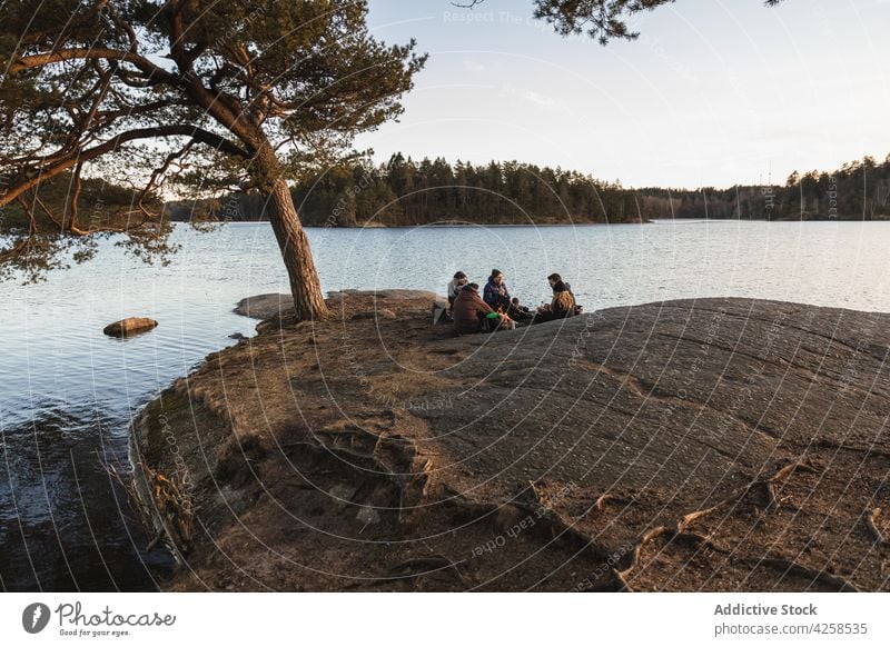 Anonymous hikers resting on lake shore and having picnic people camp traveler forest together relax nature friend landscape recreation adventure scenic tourism