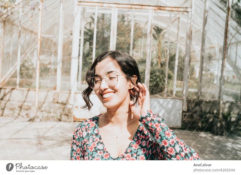 Young Moroccan woman smiling to camera in autumnal and desaturated colors with copy space and modern clothes curly hipster teenager female moroccan young