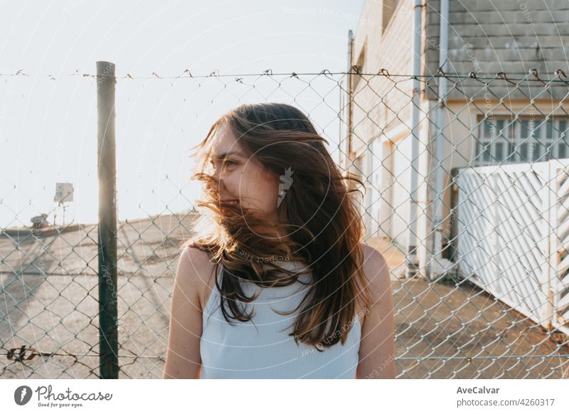 Young woman with long hair moving his hair during a sunset with liberty and freedom concept and mental health with copy space model smile wind face happy urban