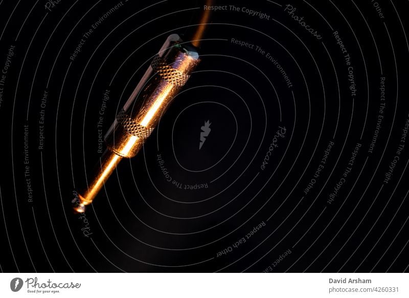 Macro Closeup of Isolated Metal Male Quarter Inch Audio Cable Connector on Black Background quarter inch jack instrument cable audio cable 1/4 inch cord