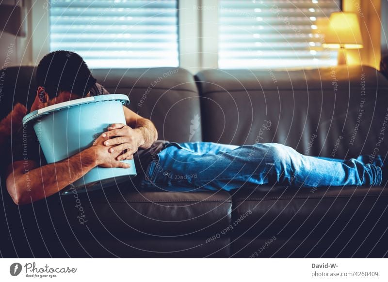 nausea - man with bucket on the sofa Vomiting Nausea hangover mood Sick Man Bucket To break (something) unwell Margins Intestine Sofa Lie swill Alcoholic drinks