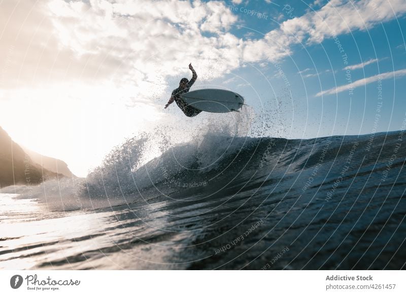 Unrecognizable athlete practicing surfing on ocean wave surfer practice sport extreme energy sea man dynamic flow fast activity brave talent skill cloudy sky