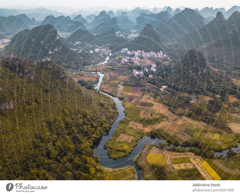 Wavy river between lush green trees in city lawn nature landscape environment ecology vegetate house wavy water narrow roof architecture residential picturesque