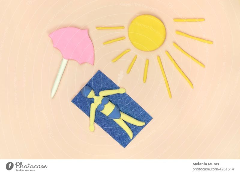 Women laying on the beach under pink umbrella taking a sunbath in bikini on the towel. Top view, artificial scene. Concept of summer holiday. above view