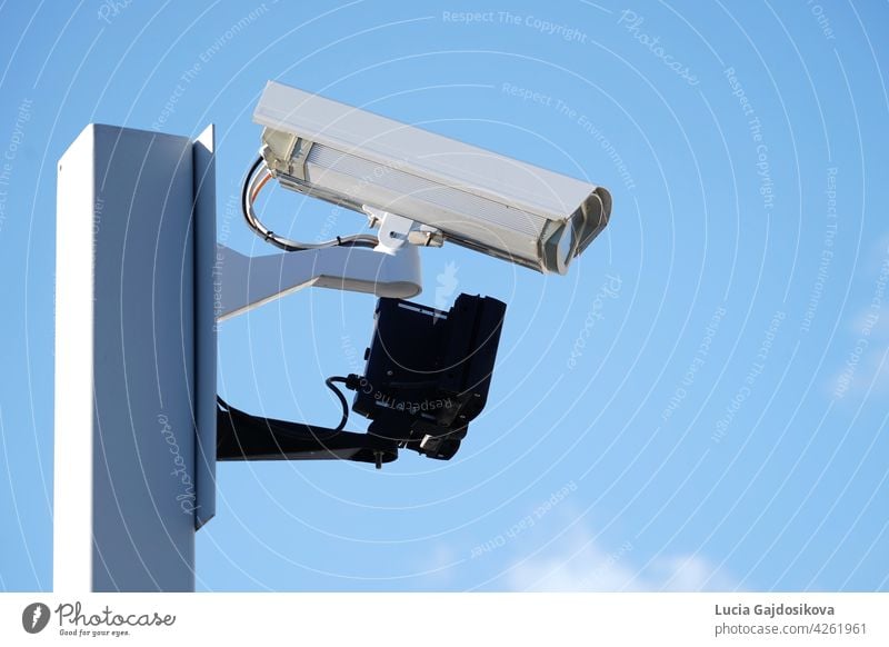 Industrial Security CCTV Camera installed on metal fence. The camera protects the industrial ground. Blue sky is on the background. building cctv control