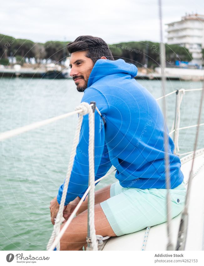 Ethnic man contemplating river from yacht in town admire lake content masculine macho sincere city portrait motorboat smile virile friendly contemplate ethnic