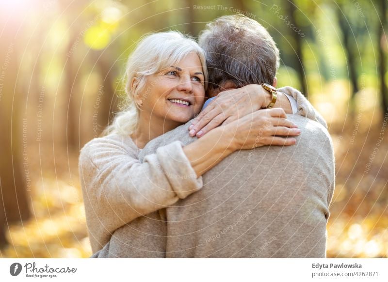 Elderly couple embracing in autumn park family woman love people outdoors portrait together nature two beautiful fall trees yellow senior mature seniors