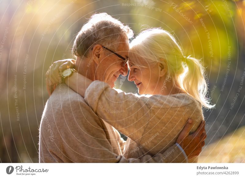 Elderly couple embracing in autumn park family woman love people outdoors portrait together nature two beautiful fall trees yellow senior mature seniors