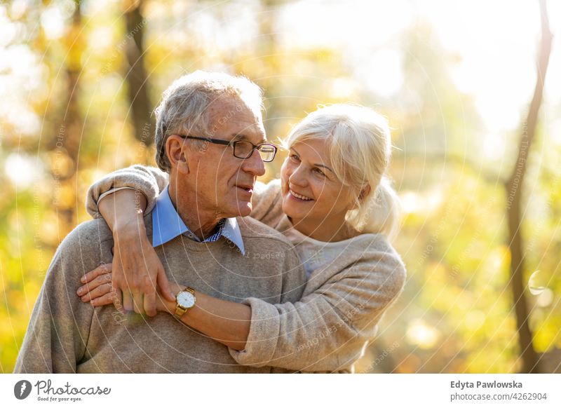 Senior couple in autumn park family woman love people outdoors portrait together nature two beautiful fall trees yellow senior mature seniors pensioner