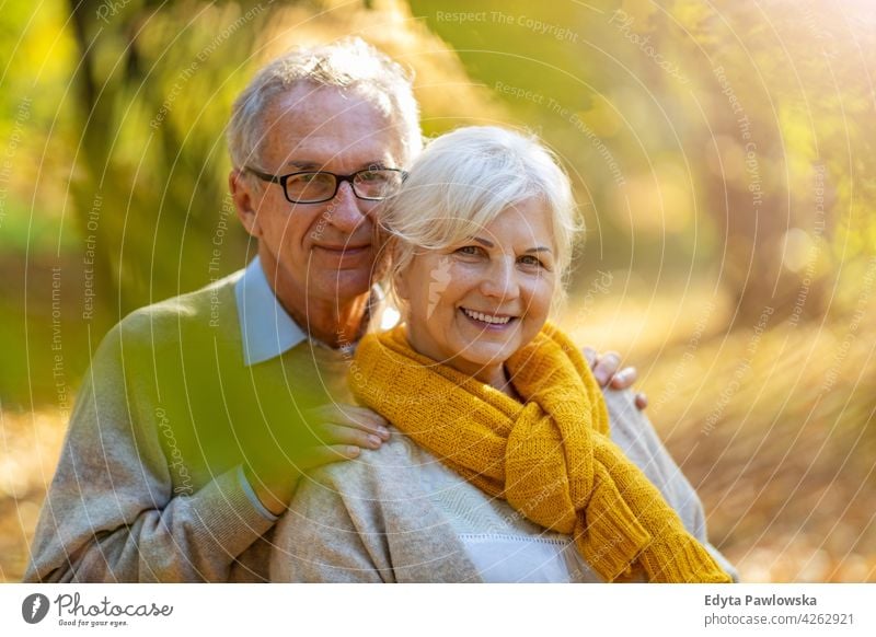 Senior couple in autumn park family woman love people outdoors portrait together nature two beautiful fall trees yellow senior mature seniors pensioner