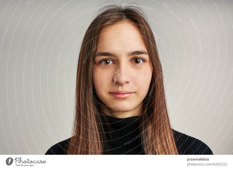 Portrait of young woman. Classic portrait in positive mood, beautiful model posing in studio over plain background headshot person female teenager pretty lady