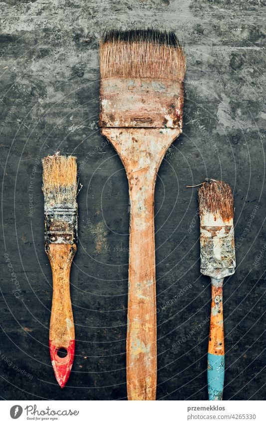 Paintbrushes on metal surface. Old brush set for house maintenance. Technical background hardware tool steel old used heavy useful workshop improvement supply