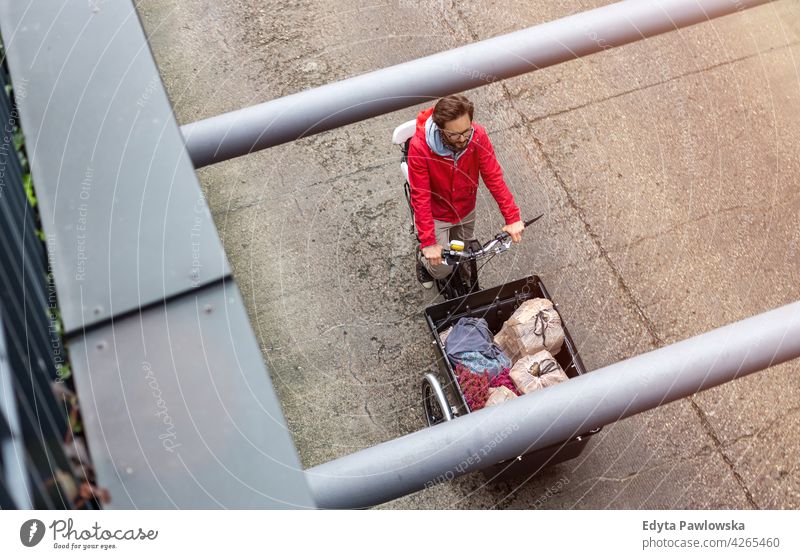 Man going back from shopping with a cargo bike carrying tricycle day healthy lifestyle active outdoors joy bicycle biking activity cyclist enjoying bike ride