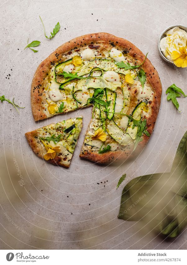 Delicious pizza with zucchini slices on gray background cheese arugula sesame food lunch seasoning baked delicious vegetable knife squash flower seed black