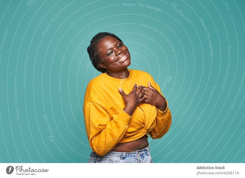 Content black woman dancing happily on blue background dance happy cheerful style outfit trendy vivid energy cool entertain optimist colorful positive