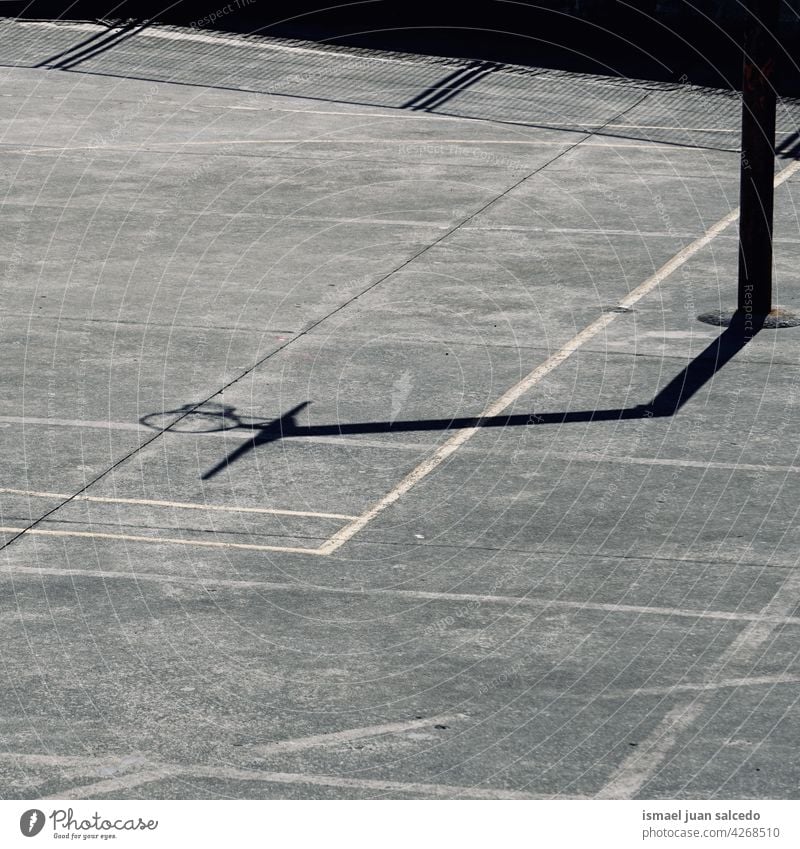 street basketball hoop shadow silhouette on the court net sunlight ground field floor sport equipment game competition play playing abandoned park playground