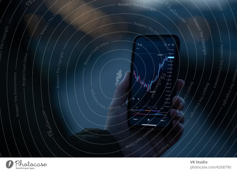 Live forex graph chart on smartphone screen stock finance data investment trader mobile phone market digital currency bitcoin index touch looking reading modern