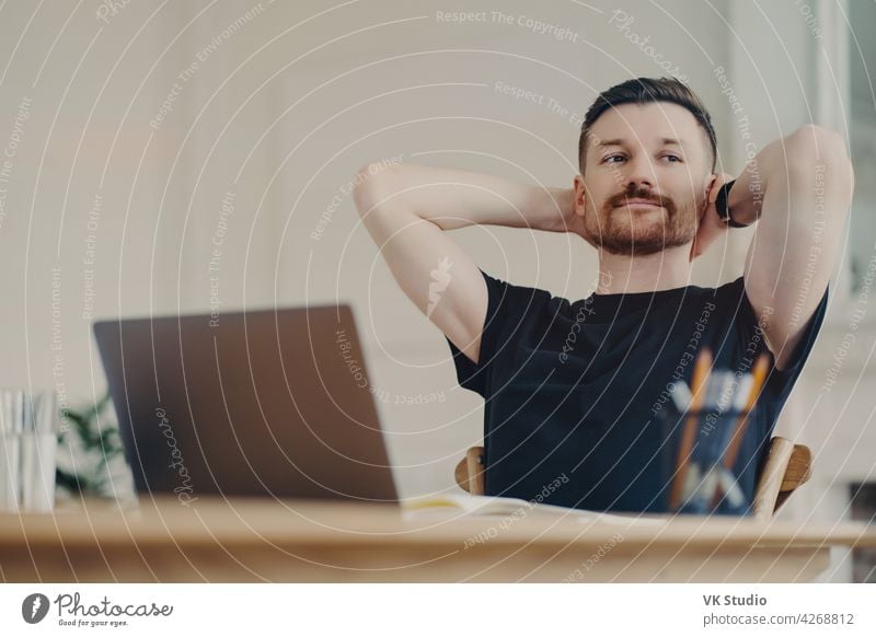 Happy business person resting after work while sitting at his workplace at home freelancer businessman office worker relaxed laptop happy work done computer