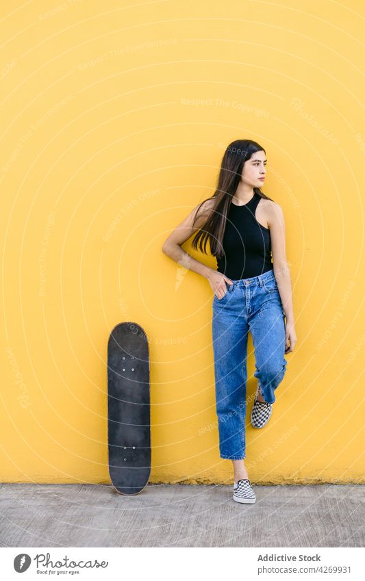 Skateboarder in casual apparel on pavement on yellow background skater skateboard cool contemporary generation spare time lifestyle teen equipment sport