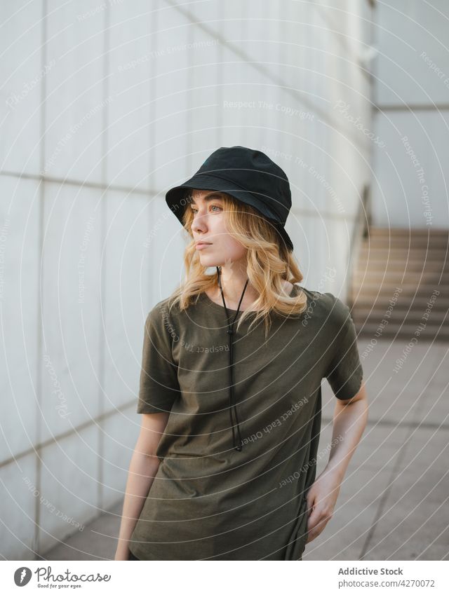 Millennial woman on concrete wall in town individuality style casual feminine gentle lifestyle urban tender romantic wistful dreamy contemplate street style