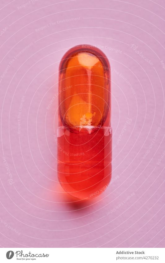 Orange pills on pink surface drug medication capsule cure composition orange remedy vitamin treat pharmacy health care concept colorful pharmaceutical