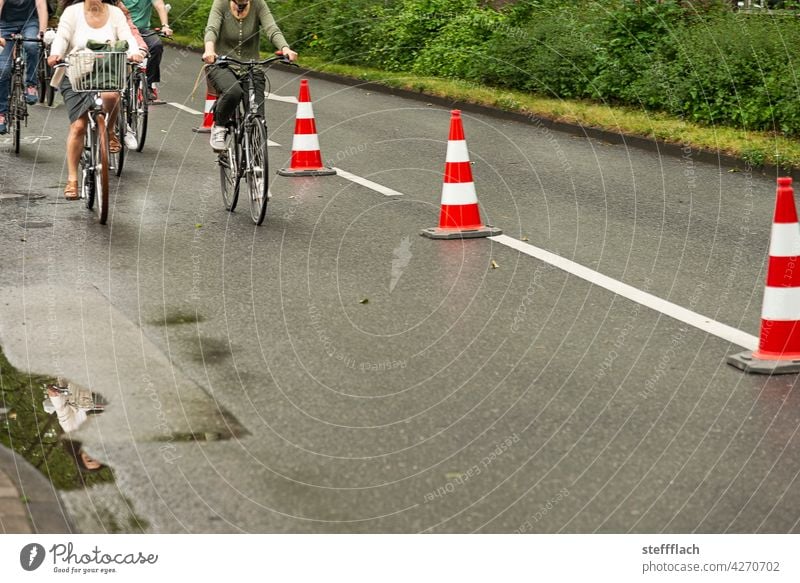 Bicyclists on a half of the road closed off with traffic cones Bicycle Cycling Cycle path, traffic, road, environment, city, urban bicycles persons turnaround