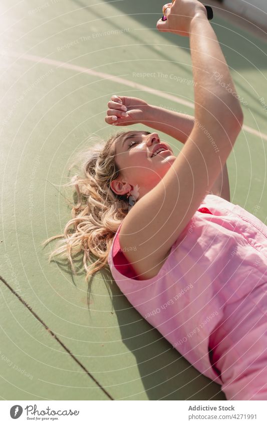 Young woman lying on ground and taking photos on camera take photo photo camera glad selfie photography device eyes closed photographer shoot memory positive