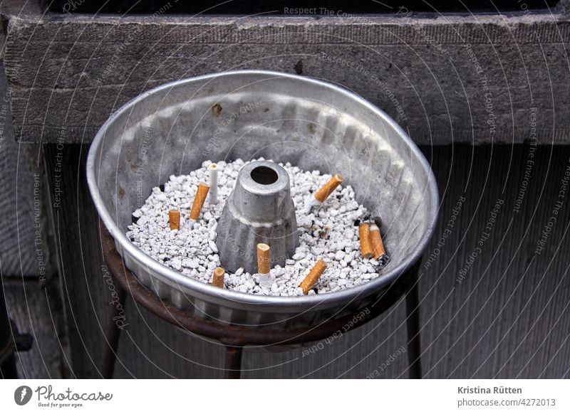 tipping in the cake tin Ashtray cigarette butt Cigarette Butt Cake tin Baking tin Smoking smoking break cigarettes Nicotine Addiction Vice phrase Unhealthy