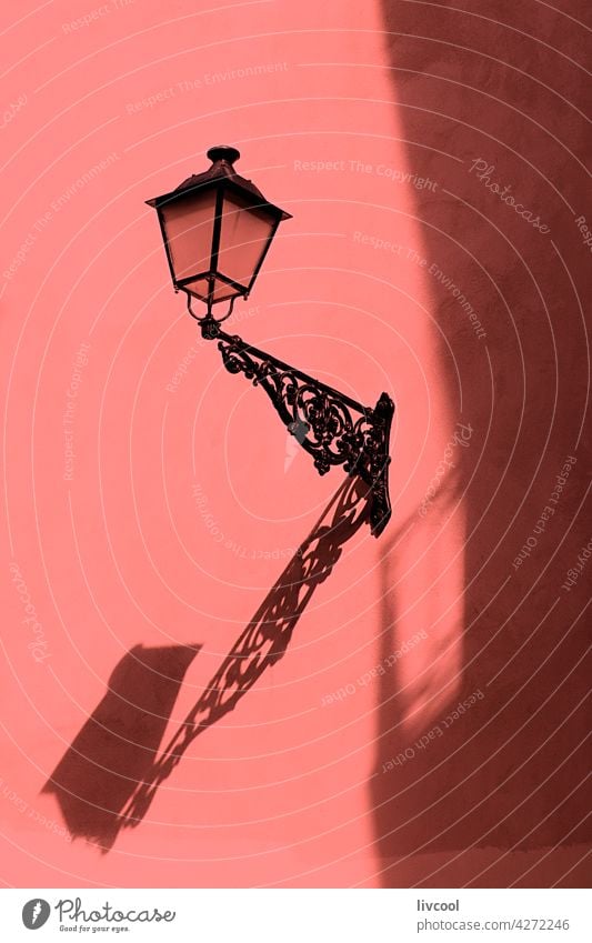 lamppost in a city alley light shadow wall facade house edifice old part neighborhood building architecture detail black coral color antique lamppost donostia