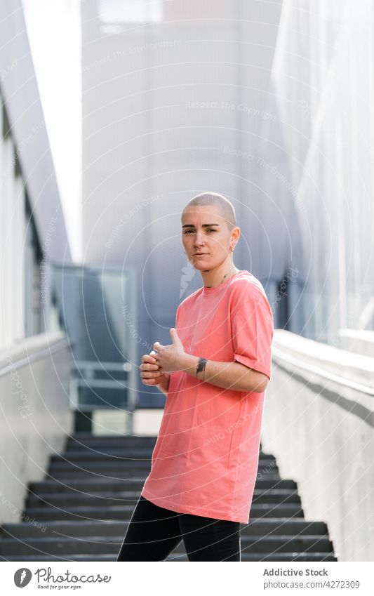 Queer on urban stairs between modern buildings queer transsexual androgynous identity accept serious architecture city confident person transgender non binary