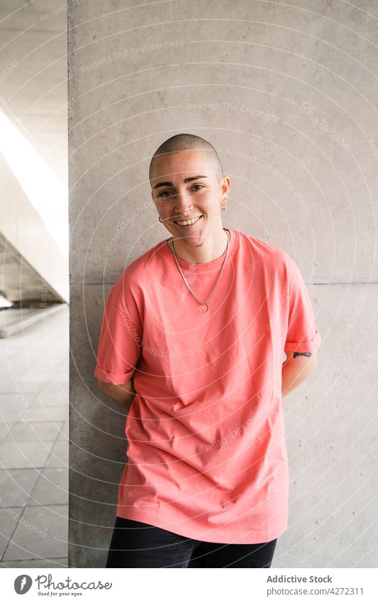 Androgynous person on tiled floor in building androgynous transgender smile accept cheerful identity happy non binary queer delight architecture transsexual