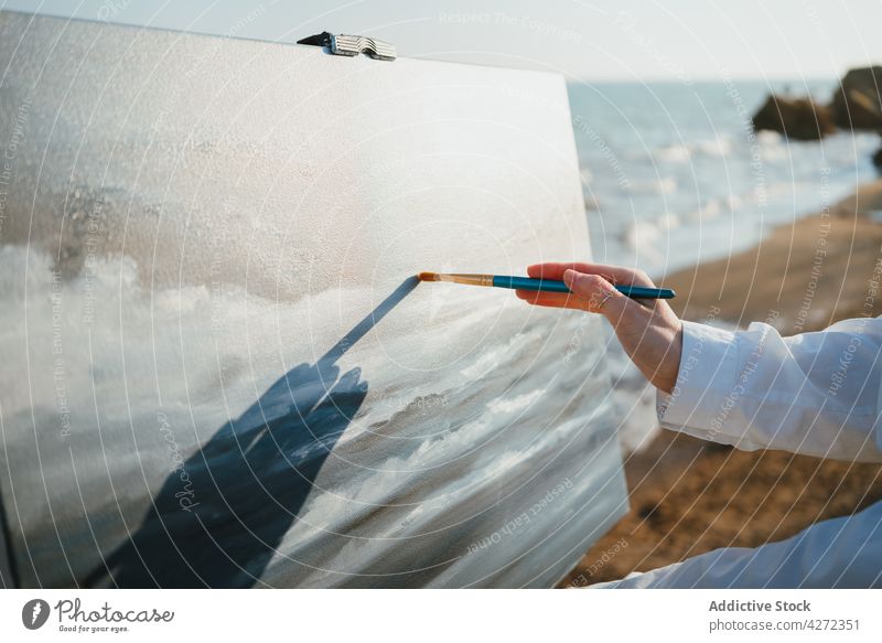 Female artist on shore near sand and sea while painting woman draw hobby canvas female young easel beret creative artwork style white shirt jeans talent lady