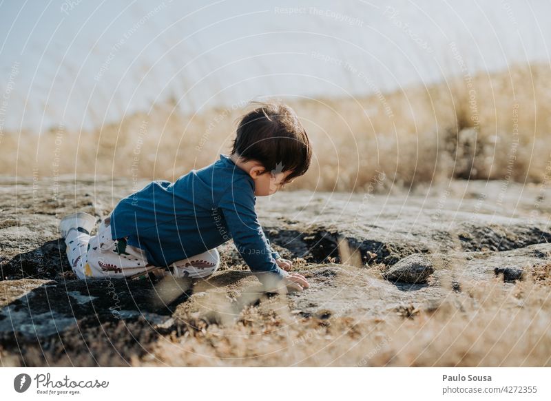 Child playing outdoors childhood 1 - 3 years Caucasian Summer Nature Curiosity explore Authentic Cute Infancy Happiness Joy Lifestyle Colour photo Exterior shot