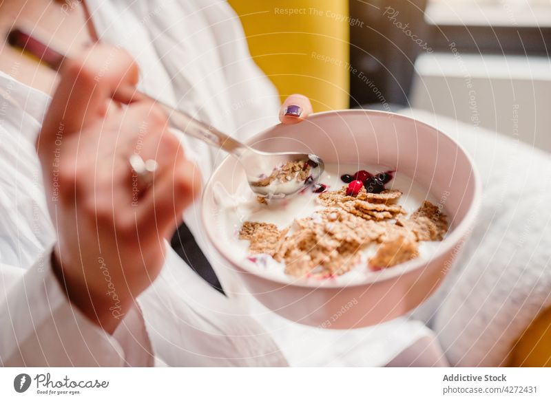 Woman eating healthy breakfast from bowl woman cereal berry yogurt meal morning nutrition female delicious diet food yummy tasty healthy food portion sweet