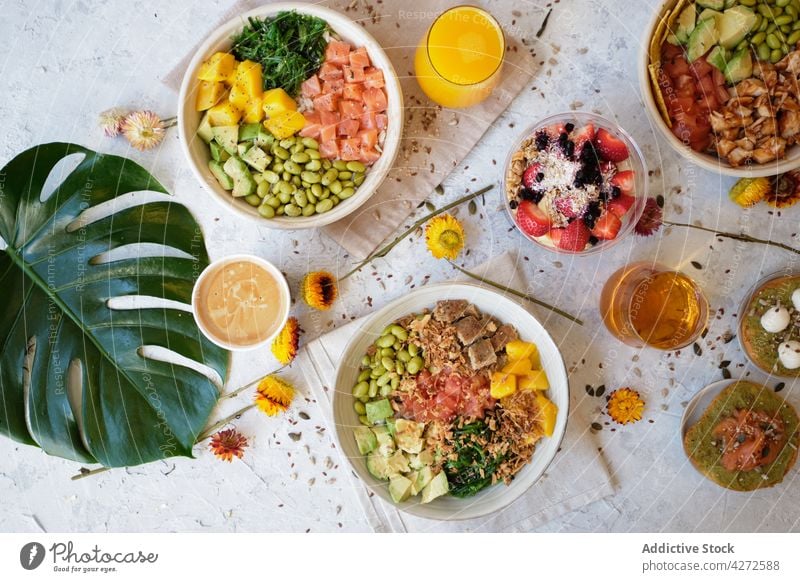 Delicious poke bowls served on table with toasts and beverages in daylight juice berry dessert food delicious assorted fresh tasty meal bean salmon chicken