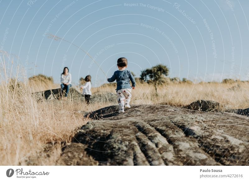 Child playing outdoors with family Family & Relations explore Rock Adventure travel Summer Rear view Lifestyle Human being Day Together Boy (child) Colour photo