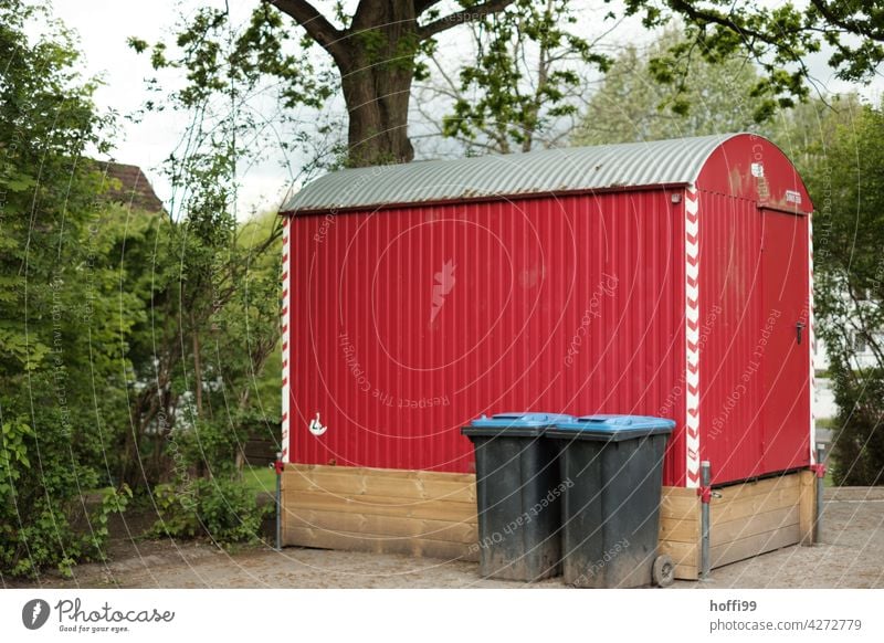 red construction trailer in front of tree with two waste paper bins on a schoolyard construction car scene Site trailer Red Waste paper bin Construction site