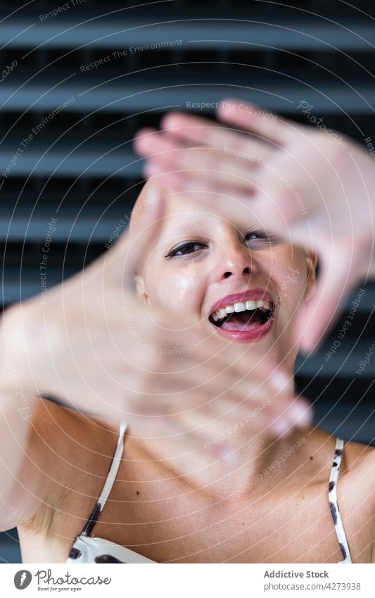 Positive young bald woman showing camera and smiling gesture smile positive alopecia trendy individuality delight style glad street female outfit hairless joy