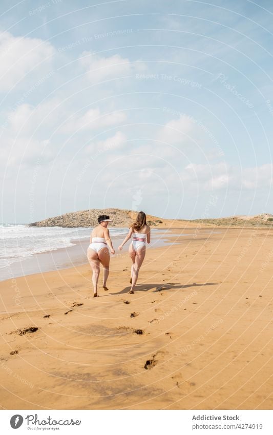 Ladies running sea near sandy coast women ocean friend happy having fun beach swimsuit blue sky female seashore summertime carefree young best friend girlfriend