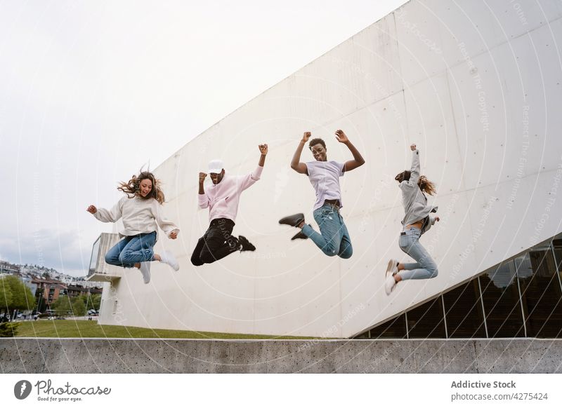 Happy diverse friends having fun together in park women rejoice glad satisfied gather excited delight male female joy carefree optimist arms raised unity happy