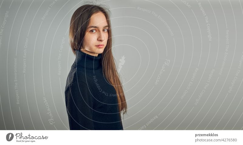 Portrait of young woman. Classic portrait in positive mood, beautiful model posing in studio over plain background headshot person female teenager pretty lady